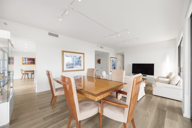 3831 Turtle Creek Blvd Unit 7E, Dallas, TX 75219 - dining area with rail lighting, visible vents, and light wood-style flooring