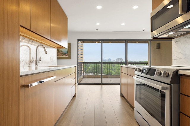 3831 Turtle Creek Blvd Unit 7E, Dallas, TX 75219 - kitchen featuring decorative backsplash, modern cabinets, a sink, light wood finished floors, and appliances with stainless steel finishes
