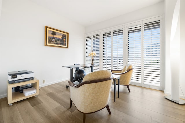 3831 Turtle Creek Blvd Unit 7E, Dallas, TX 75219 - sitting room featuring baseboards, a wealth of natural light, and wood finished floors