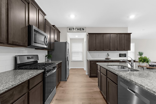 4016 Glastonbury Rd, Mckinney, TX 75071 - kitchen with stainless steel appliances, dark brown cabinetry, stone countertops, and a sink