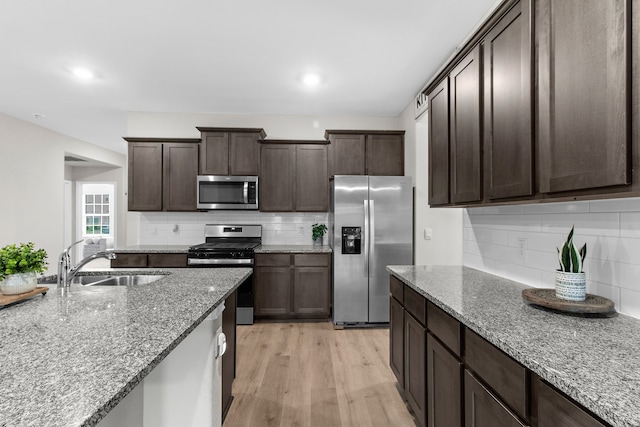 4016 Glastonbury Rd, Mckinney, TX 75071 - kitchen featuring a sink, appliances with stainless steel finishes, decorative backsplash, and light wood finished floors