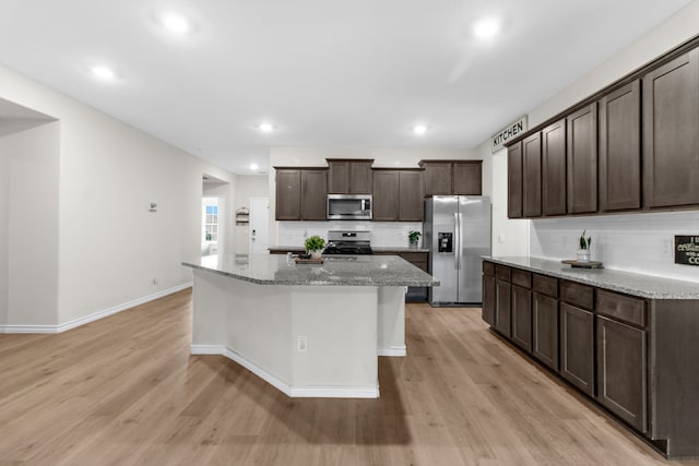 4016 Glastonbury Rd, Mckinney, TX 75071 - kitchen with appliances with stainless steel finishes, dark brown cabinetry, backsplash, and light wood-style flooring