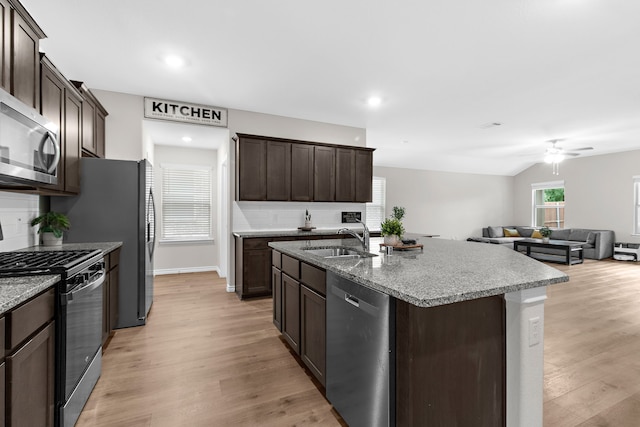 4016 Glastonbury Rd, Mckinney, TX 75071 - kitchen with dark brown cabinets, a sink, light wood-style flooring, appliances with stainless steel finishes, and backsplash