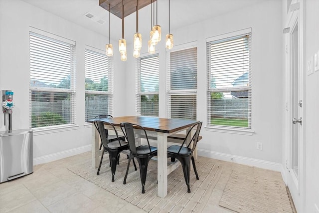 dining area with baseboards, visible vents, and a chandelier