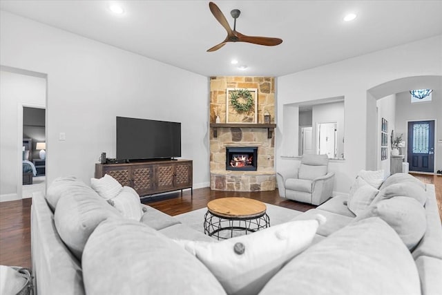 living area featuring ceiling fan, a fireplace, arched walkways, recessed lighting, and wood finished floors