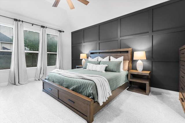 carpeted bedroom featuring ceiling fan, baseboards, and a decorative wall