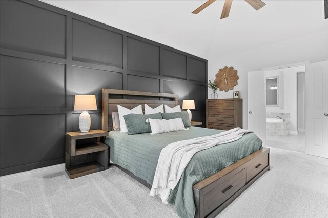 bedroom with ceiling fan, light colored carpet, ensuite bath, a decorative wall, and visible vents