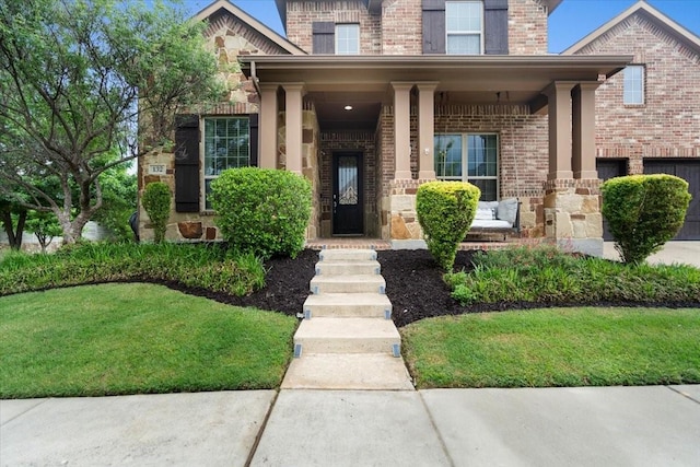 entrance to property featuring covered porch and brick siding
