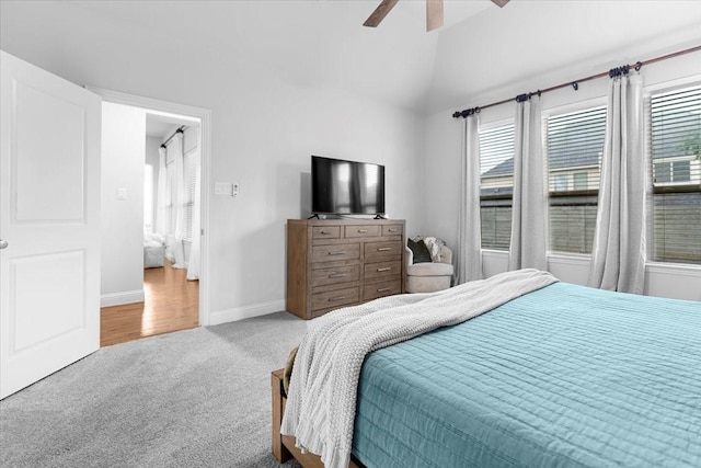 bedroom featuring baseboards, carpet flooring, lofted ceiling, and multiple windows