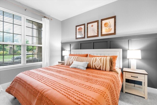 carpeted bedroom with baseboards and multiple windows