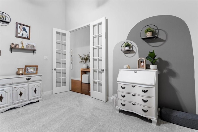 interior space with french doors, baseboards, and light carpet