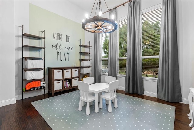 dining area featuring baseboards, wood finished floors, and a notable chandelier