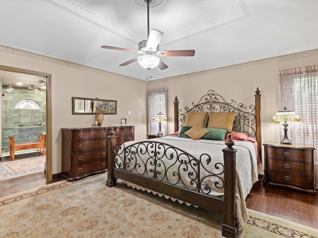 bedroom with crown molding, a ceiling fan, ensuite bathroom, and wood finished floors