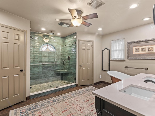 full bath with visible vents, vanity, wood finished floors, ceiling fan, and a shower stall