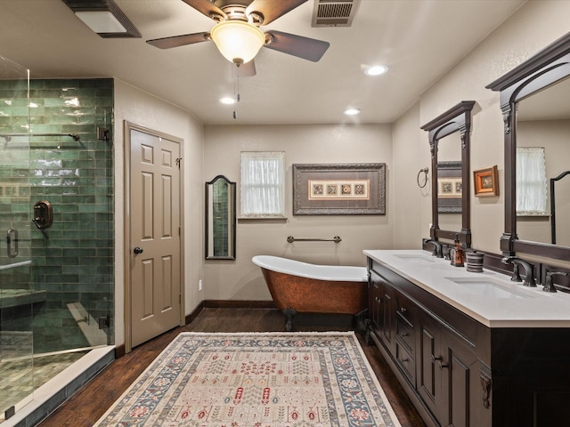 full bathroom featuring visible vents, a shower stall, wood finished floors, a sink, and a soaking tub