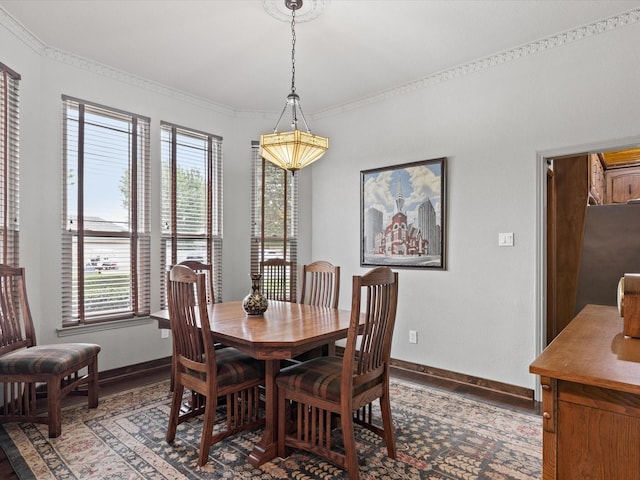 dining room featuring crown molding, baseboards, and light wood-type flooring