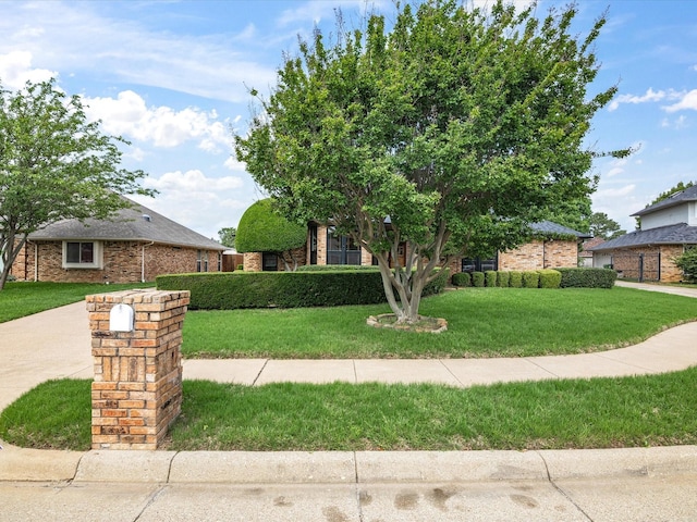 view of property hidden behind natural elements featuring a front lawn