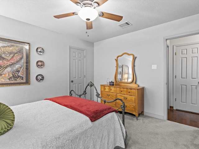 bedroom with carpet flooring, a ceiling fan, and visible vents