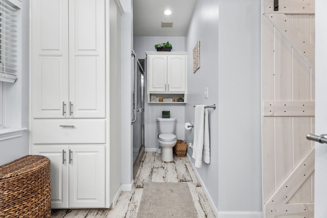 full bathroom with baseboards, a shower stall, toilet, and visible vents