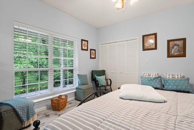 bedroom with baseboards, wood finished floors, and a closet