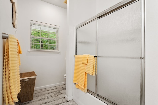 bathroom featuring baseboards, toilet, and wood finished floors