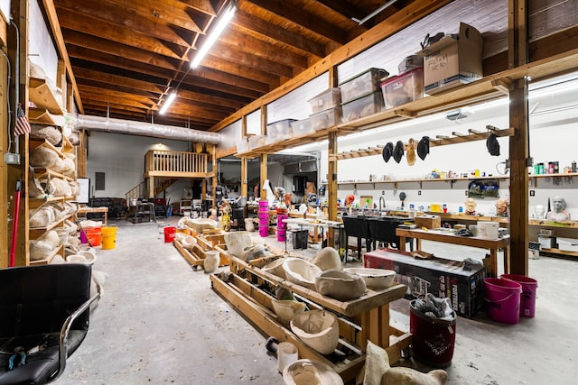 misc room featuring a workshop area and unfinished concrete flooring