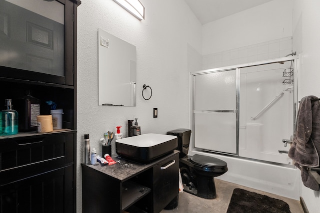 full bath featuring vanity, concrete floors, enclosed tub / shower combo, and toilet