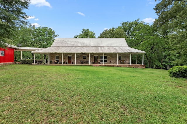 back of house featuring a porch, a yard, brick siding, and metal roof