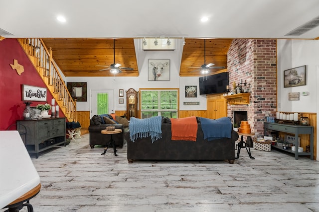 living room featuring visible vents, wood finished floors, ceiling fan, stairway, and wood ceiling