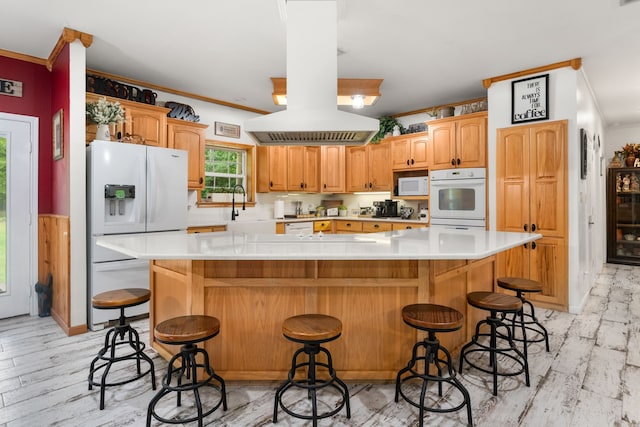 kitchen featuring crown molding, white appliances, light countertops, light wood-type flooring, and a spacious island
