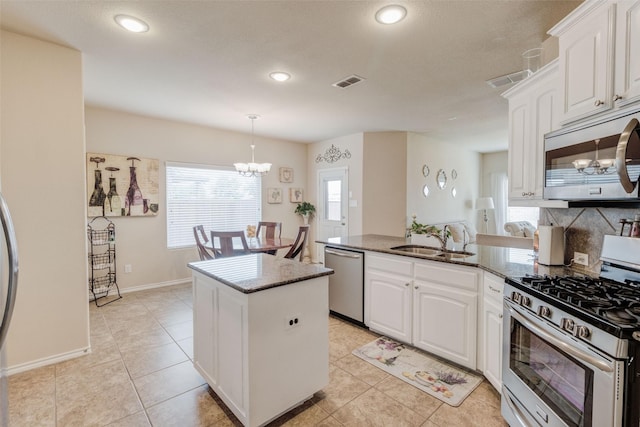 kitchen with visible vents, an inviting chandelier, dark stone counters, a sink, and stainless steel appliances