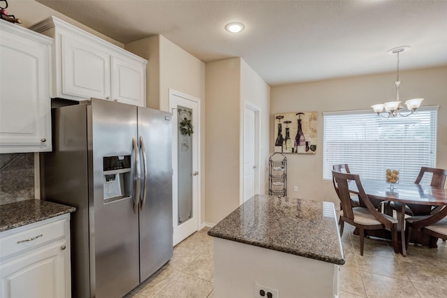 kitchen featuring stainless steel fridge, a center island, white cabinets, and a notable chandelier