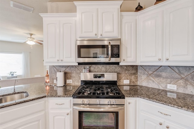 kitchen with visible vents, a ceiling fan, white cabinets, a sink, and stainless steel appliances