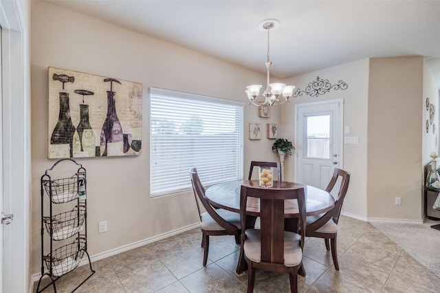 dining space with an inviting chandelier, tile patterned floors, and baseboards