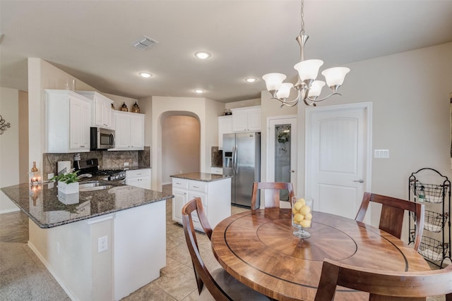dining space featuring an inviting chandelier, arched walkways, recessed lighting, baseboards, and visible vents
