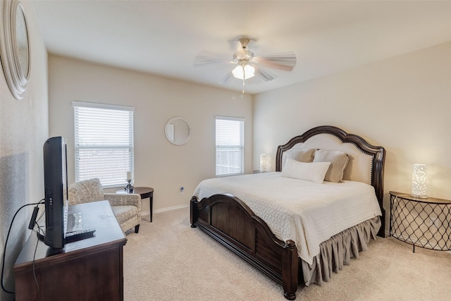 bedroom featuring light colored carpet, a ceiling fan, and baseboards