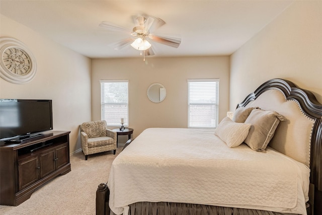 bedroom featuring multiple windows, ceiling fan, and light colored carpet