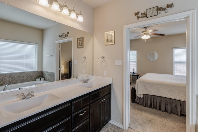 bathroom with connected bathroom, ceiling fan, a wealth of natural light, and a sink