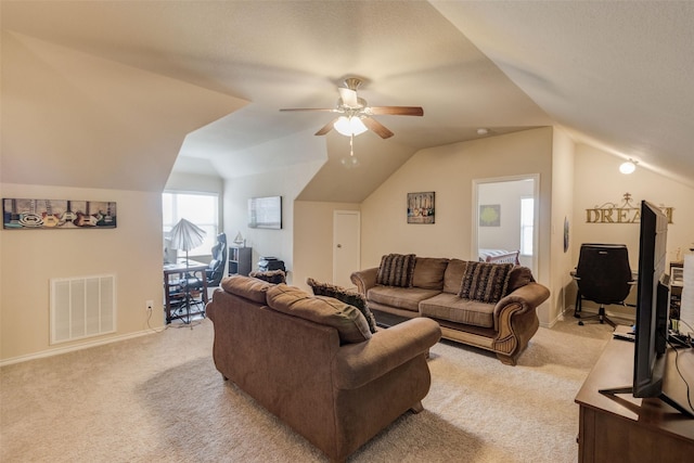 living area with visible vents, a ceiling fan, lofted ceiling, and light colored carpet