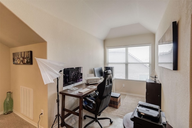 carpeted office featuring baseboards, visible vents, and vaulted ceiling