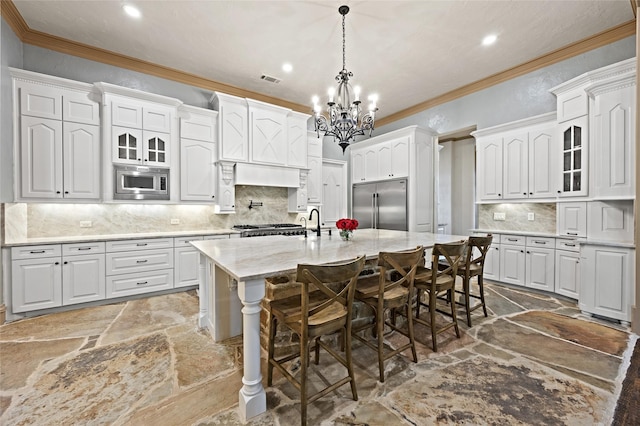 1237 Wales Dr, Mclendon Chisholm, TX 75032 - kitchen with built in appliances, stone tile flooring, a chandelier, recessed lighting, and a center island with sink