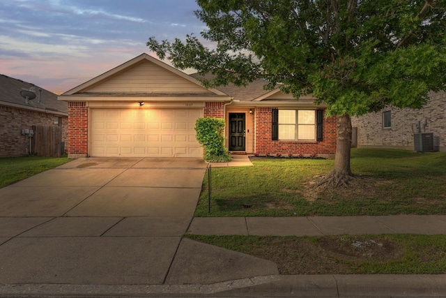 ranch-style home with brick siding, an attached garage, driveway, and a front yard