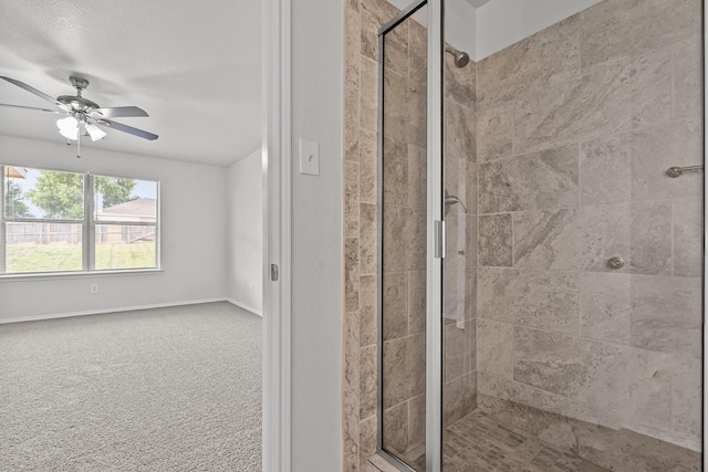 bathroom featuring a ceiling fan, baseboards, and a stall shower