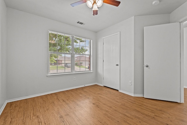 unfurnished bedroom featuring baseboards, a ceiling fan, wood finished floors, and visible vents