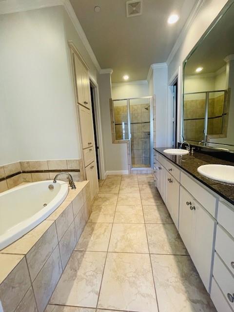 full bathroom featuring a bath, visible vents, a shower stall, a sink, and ornamental molding