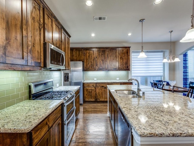 5517 Grove Cove Dr, Mckinney, TX 75071 - kitchen with visible vents, decorative backsplash, dark wood-style floors, a sink, and stainless steel appliances