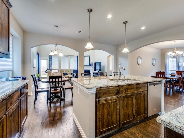 5517 Grove Cove Dr, Mckinney, TX 75071 - kitchen with stainless steel dishwasher, a kitchen island with sink, arched walkways, a chandelier, and a sink