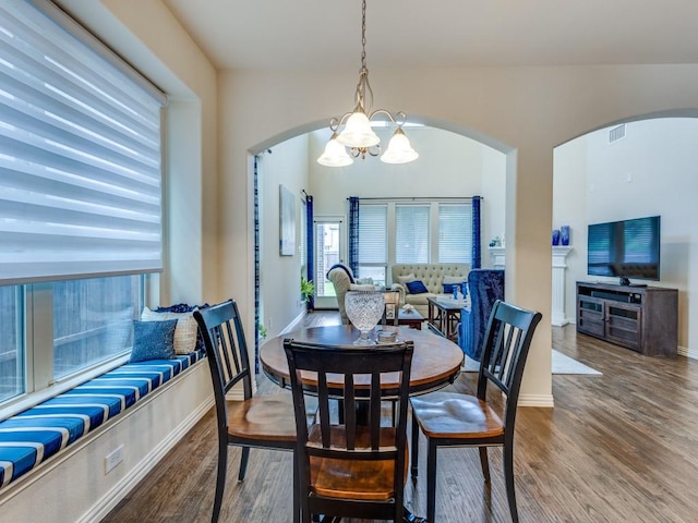 5517 Grove Cove Dr, Mckinney, TX 75071 - dining area with visible vents, arched walkways, wood finished floors, and a notable chandelier