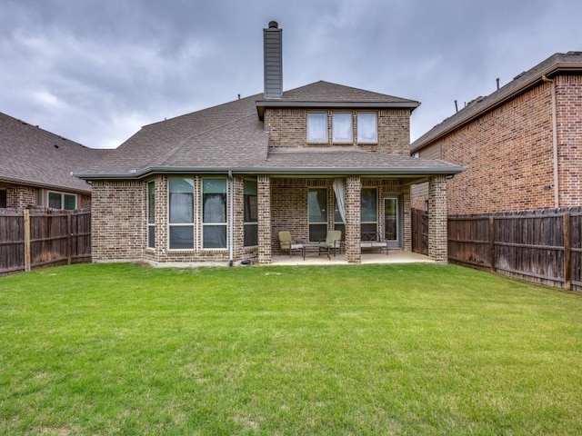 5517 Grove Cove Dr, Mckinney, TX 75071 - back of property with a patio, a fenced backyard, a chimney, brick siding, and a yard