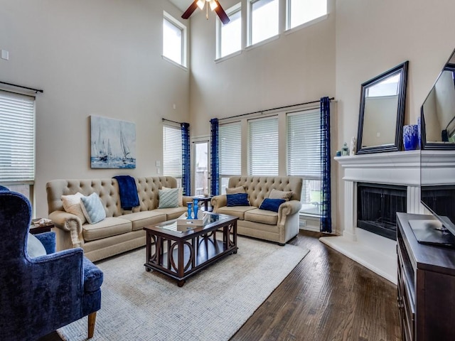 5517 Grove Cove Dr, Mckinney, TX 75071 - living area with a ceiling fan, dark wood finished floors, a fireplace with raised hearth, and a high ceiling